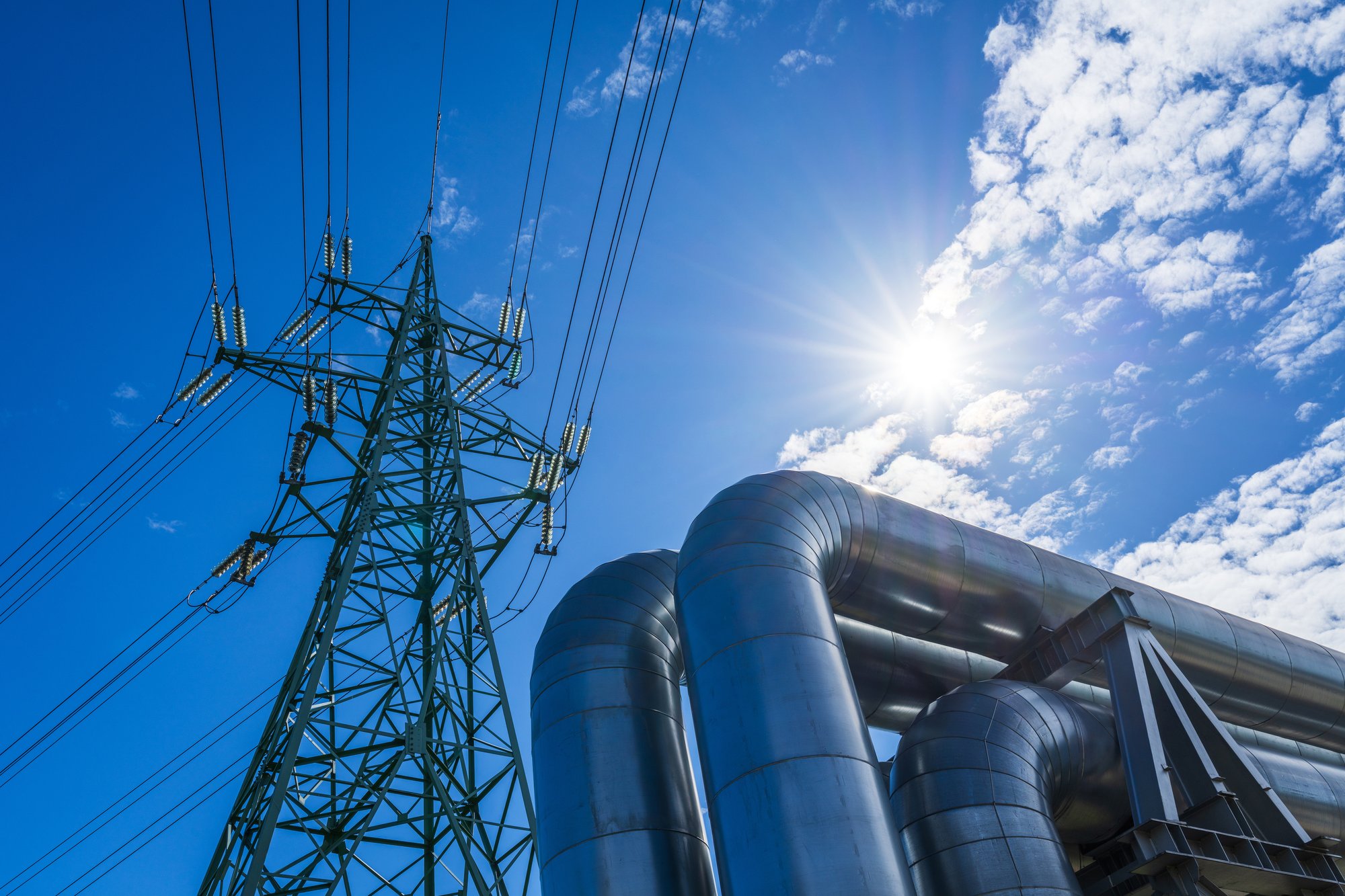 Industrial pipelines on pipe-bridge against blueiStock-2153867667